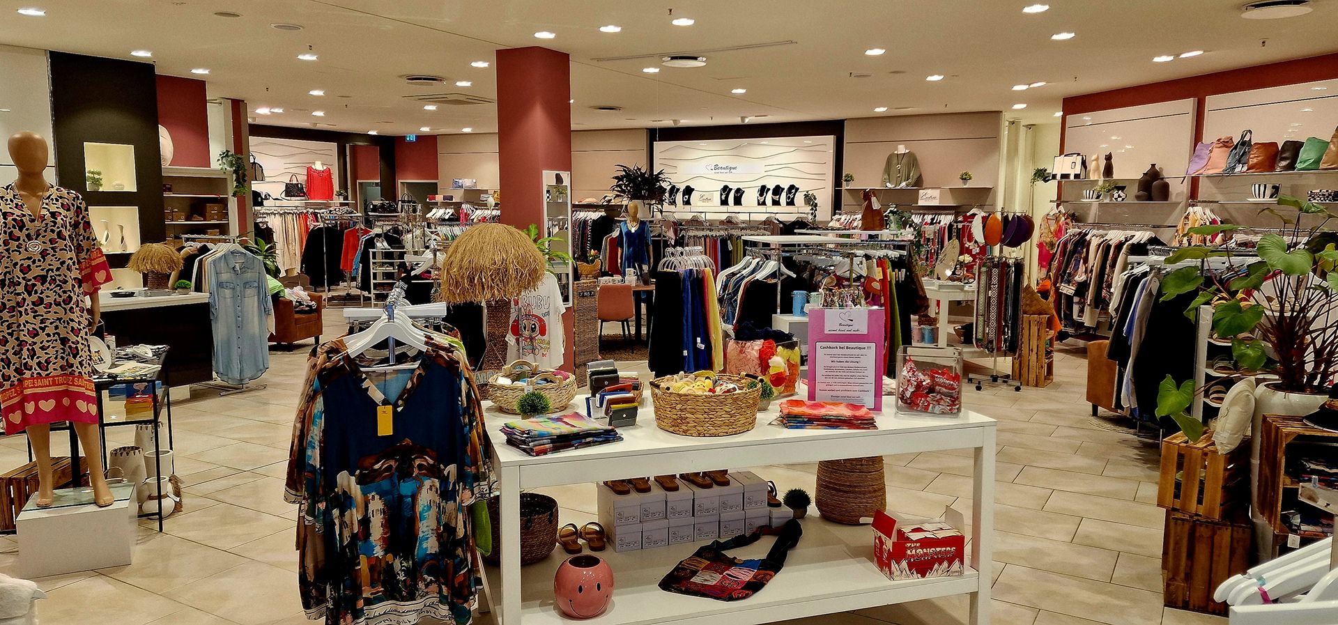 Verkaufsraum mit nachhaltiger und aktueller Mode auf Tischen und Kleiderständern